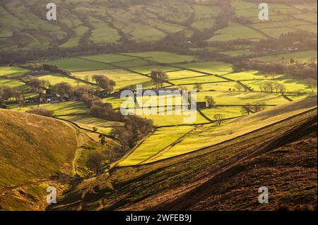 Winter sunlight over fields in the Vale of Edale seen from Kinder Scout in the Peak District National Park Stock Photo