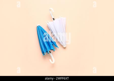 Mini stylish umbrellas on beige background Stock Photo