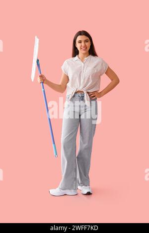 Young woman with floor mop on pink background Stock Photo