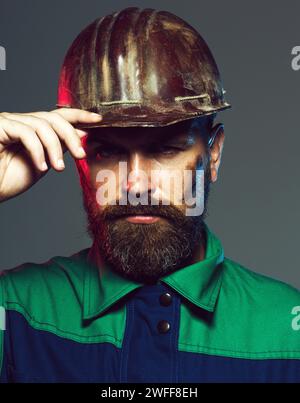 Closeup portrait of serious builder in construction helmet. Hard work. Handsome male architect or engineer in hard hat. Bearded man in protective Stock Photo