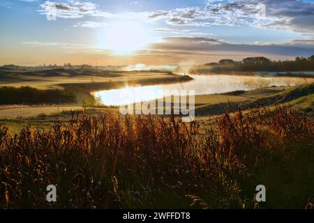 Sunrise on the golf course with fog and mist in a pond Stock Photo