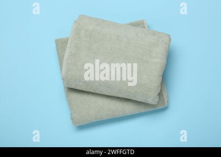 Folded terry towels on light blue background, top view Stock Photo