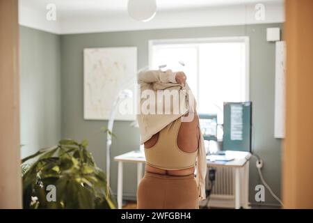 Rear view of woman with disability wearing dress while standing at home Stock Photo