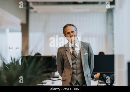Portrait of smiling mature businessman standing in office Stock Photo