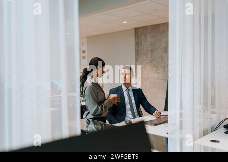 Smiling businessman and businesswoman talking in office Stock Photo