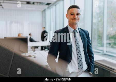Portrait of confident young businessman standing at corporate office Stock Photo