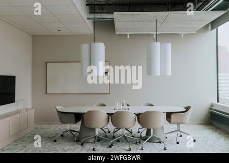 Empty conference table with chairs and pendant light in board room Stock Photo