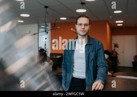 Portrait of confident young businessman standing in office Stock Photo