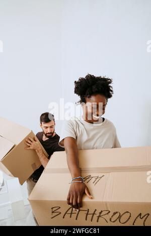 Multiracial couple carrying cardboard boxes at home Stock Photo