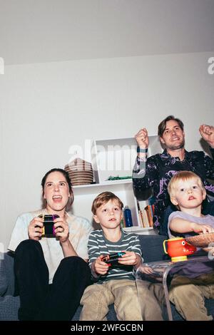 Happy family enjoying while playing video game at home Stock Photo