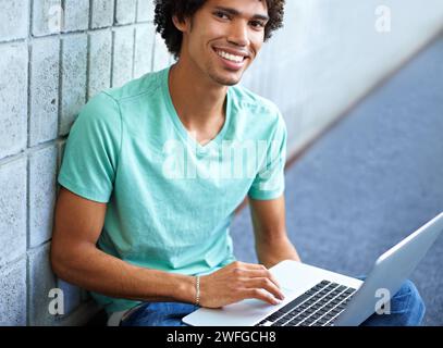 Student, black man in portrait and laptop for education, e learning and typing essay, research or planning in college. Young smart person with Stock Photo