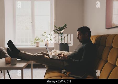 Businessman using laptop while sitting on sofa at office Stock Photo