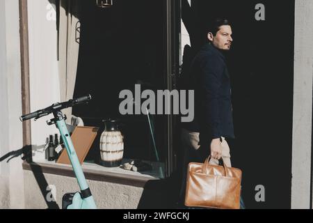 Businessman holding laptop bag while arriving at office Stock Photo