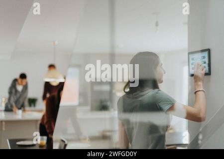 Girl using digital tablet and controlling room temperature at modern home Stock Photo