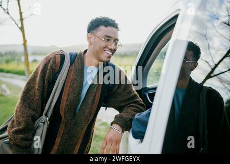 Smiling young man leaning van Stock Photo