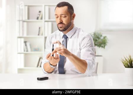 Young man pricking finger and checking blood sugar level Stock Photo
