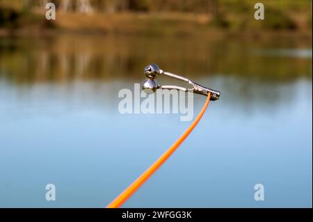 Bell on the end of a fishing pole alerts the fisherman of a strike or fish  on the end of the line Stock Photo - Alamy