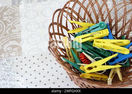 Multicolored clothespins in the wicker basket, close-up Stock Photo