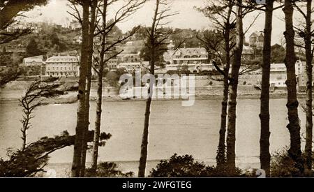 Photograph of Salcombe waterfront from across the mouth of the Kingsbridge Estuary, in the South Hams district of Devon - a resort town -  has a traditional shellfish fishing industry - now a second home hotspot.. From the book Glorious Devon. by S.P.B. Mais, published by London Great Western Railway Company, 1928 Stock Photo