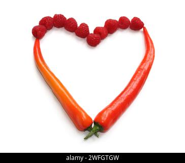 heart sign made from red orange chili pepper and raspberry, heart made of chillies, peppers, raspberries for decoration of menu cards, flyer, brochure Stock Photo