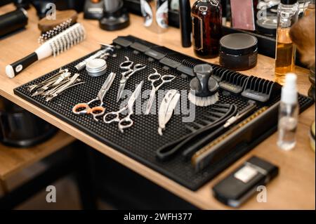 Barbers tools for mens haircuts laid out on a table close up. Set of scissors for haircuts. Stock Photo