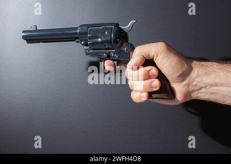 hand holding replica gun isolated on dark background Stock Photo