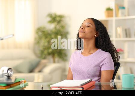 Black student breathing fresh air and relaxing at home Stock Photo