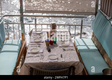 close up of table setting at open-air restaurant on beach Stock Photo