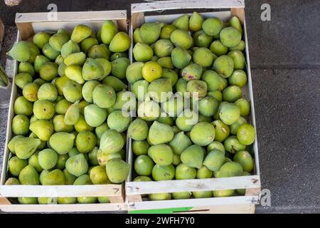 fresh green figs in wooden crates displayed on market Stock Photo