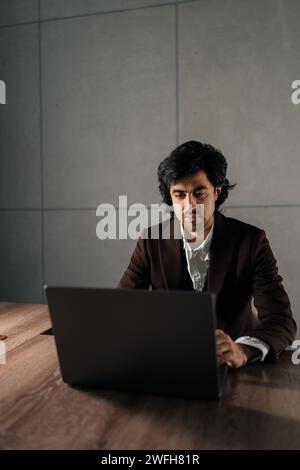 Portrait of serious focused businessman ceo using computer, typing, working in modern office, doing online data market analysis, thinking planning Stock Photo