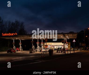 Sainsbury's petrol and diesel station at Torquay Devon UK. Night time photography of vehicles at the pumps. Stock Photo