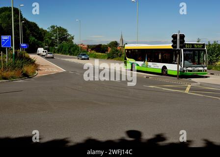 Road junction at the entrance to the car park at Britford Park and Ride, near Salisbury, Wiltshire, as a bus arrives. Stock Photo