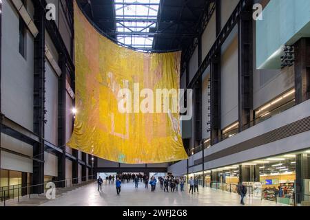 London, UK-December 12, 2023; Turbine Hall of Tate Modern art gallery with artwork of cascading metal hangings Behind The Red Moon of artist El Anatsu Stock Photo