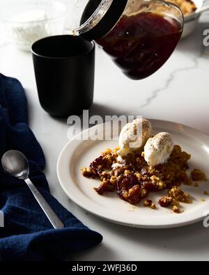 Apple Crumble Pie with vanilla ice cream scoops made from caramelized apples with spices. High-key photo, white marble background. breakfast concept Stock Photo