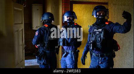 Hohenbostel, Germany. 03rd Jan, 2024. Police officers from the Lüneburg disposition unit practise entering a building. Credit: Philipp Schulze/dpa/Alamy Live News Stock Photo