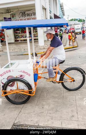 Merida Mexico,centro historico central historic district,Calle 56A,shopping district,man men male,adult adults,resident residents,riding pedaling bike Stock Photo