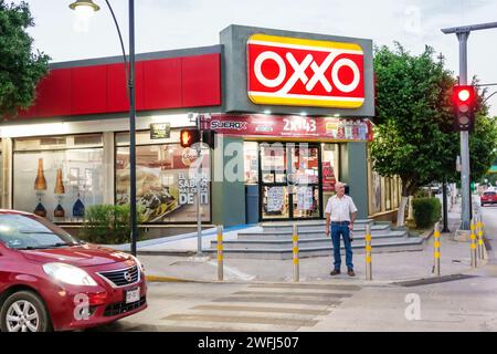 Merida Mexico,Centro,Oxxo convenience food store business bodega grocery,outside exterior front entrance evening night,man men male,adult adults,resid Stock Photo