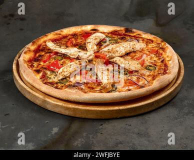 A delicious pizza with ham, mozzarella, jalapenos, onions and grilled chicken Stock Photo