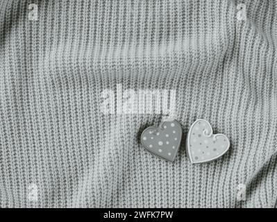 Two Heart-Shaped Pins With Polka Dot Patterns on a Knitted Fabric. Black and white Stock Photo