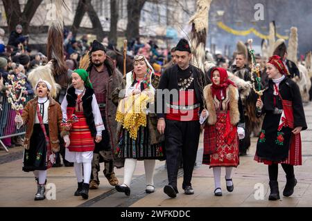 Pernik, Bulgaria - January 27, 2024: 30th anniversary Masquerade festival in Pernik Bulgaria. Men and women dressed in traditional costumes dance and Stock Photo