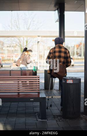 Two individuals seated on benches in a vibrant urban setting Stock Photo