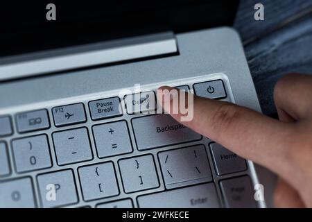 Pressing the delete button on the keyboard with your finger. Removing problems, employee, negativity Stock Photo