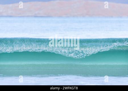 Turquoise green waves rolling and gently breaking onto the stunning Luskentyre beach Stock Photo
