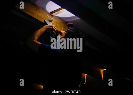 Bintangor, Sarawak, Malaysia. 31st Jan, 2024. A man harvests a bird's nest from the roof of a dimmed, two-floor high bird's nest house in the outskirts of Bintangor, Sarawak. An audio emulating the sounds of birds, designed with a specific frequency, is played continuously by multiple speakers to attract birds to fly into the house, where they nests using their salivas. (Credit Image: © Daniel Ceng Shou-Yi/ZUMA Press Wire) EDITORIAL USAGE ONLY! Not for Commercial USAGE! Stock Photo