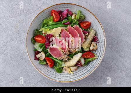 salad with carpaccio, artichoke and asparagus on a stone background, studio food photography Stock Photo
