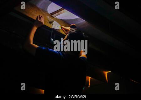 Bintangor, Sarawak, Malaysia. 31st Jan, 2024. A man harvests a bird's nest from the roof of a dimmed, two-floor high bird's nest house in the outskirts of Bintangor, Sarawak. An audio emulating the sounds of birds, designed with a specific frequency, is played continuously by multiple speakers to attract birds to fly into the house, where they nests using their salivas. (Credit Image: © Daniel Ceng Shou-Yi/ZUMA Press Wire) EDITORIAL USAGE ONLY! Not for Commercial USAGE! Stock Photo