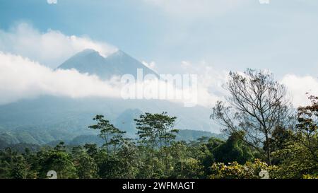 Mt Merapi enshrouded in mist and clouds - Java, Indonesia Stock Photo