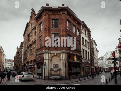 Den Spauwer fountain on the corner of the streets in central Brussels. Brick building with fountain in Belgian old town. Stock Photo