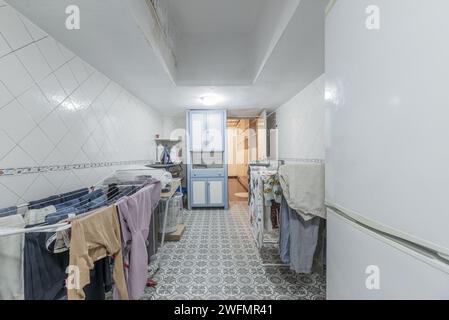 A room dedicated to laundry on the ground floor of a house full of clotheslines full of clothes Stock Photo