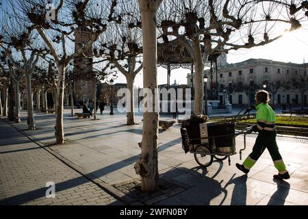 Madrid, Spain. 30 January 2024. City street cleaner in green uniform. Cleaning the streets from the garbage. Man with a cart full of garden tools. Stock Photo